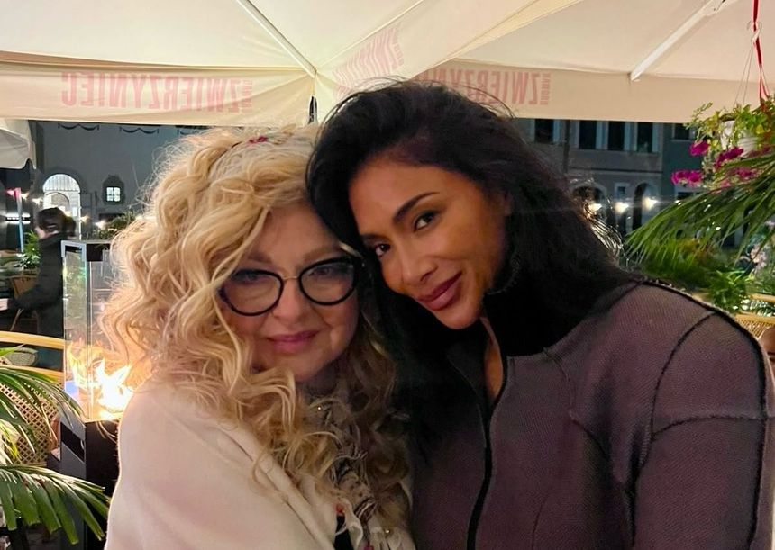 Magda Gessler i Nicole Scherzinger uśmiechają się do kamery, w tle rośliny i oświetlenie. Przyjemna, wieczorna atmosfera.