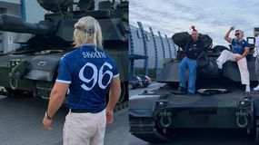 Skolim i jego przyjaciele stoją na czołgu, obok pojazdu widać budynki i zaparkowane samochody.