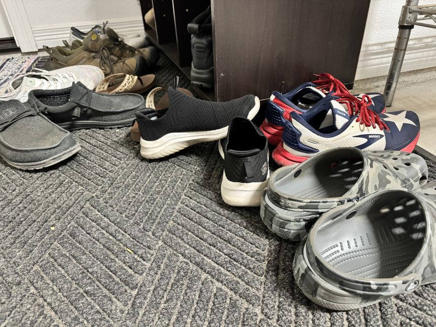 Na zdjęciu różnorodne buty leżące na dywaniku: sneakersy, klapki, crocsy i inne.