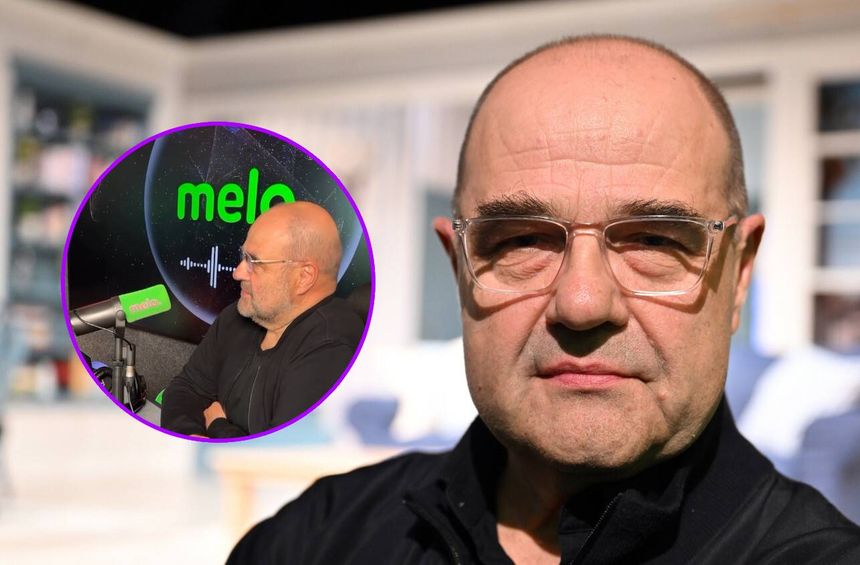 Cezary Żak w okularach, poważnym wyrazie twarzy, w czarnym ubraniu, tło rozmyte.
