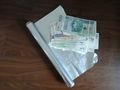 Na stole leży gotówka, folia spożywcza oraz srebrna folia.