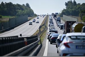 Ruch kołowy na ekspresowej drodze; prawy pas zablokowany przez stojące samochody.