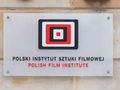 Logo Polskiego Instytutu Sztuki Filmowej na szklanej tablicy z napisami w języku polskim i angielskim.