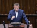 Mężczyzna w garniturze przemawia w parlamencie.