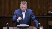 Mężczyzna w garniturze przemawia w parlamencie.