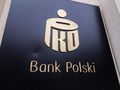 Logo banku PKO Bank Polski na czarnym tle. Złote litery i symbol bankowy.