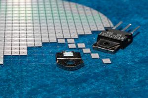 Zdjęcie przedstawia różne podzespoły elektroniczne na niebieskim tle.