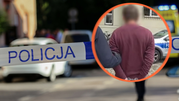 Na zdjęciu widać taśmę policyjną oraz osobę aresztowaną w niebieskim otoczeniu.