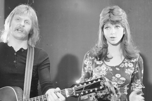 Dwoje artystów na scenie; mężczyzna z gitarą i kobieta śpiewająca. Czarno-biała fotografia.