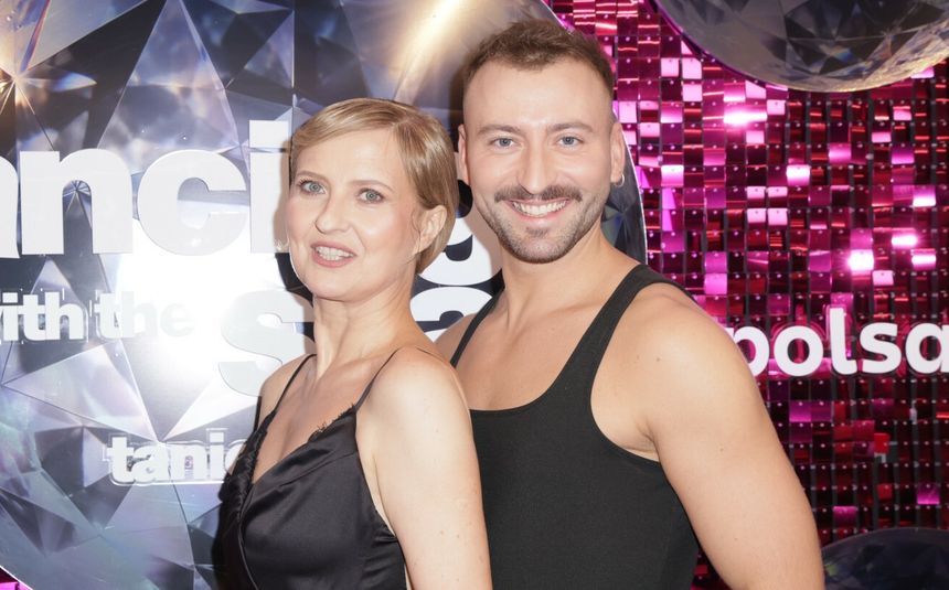 Na zdjęciu Izabela Kuna w stroju tanecznym, pozująca przed kolorowym tle.