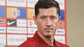 Na zdjęciu Robert Lewandowski w czerwonej koszulce, z włosami w ciemnym kolorze, wygląda poważnie.
