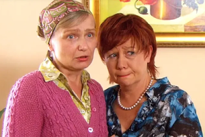 Dwie kobiety w emocjonalnej rozmowie, jedna w swetrze, druga w bluzce w kolorowy wzór.