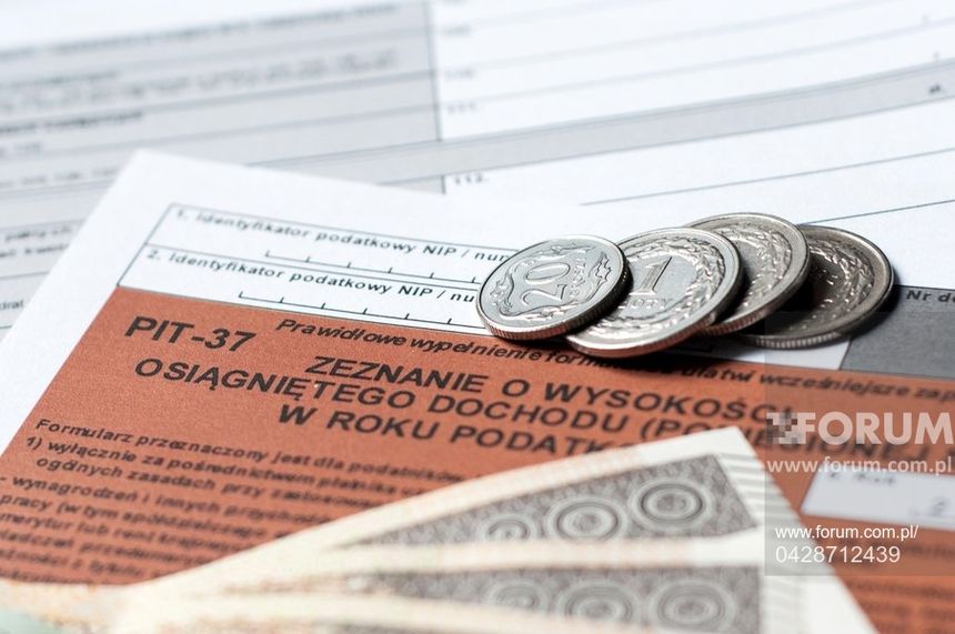 Opis ALT: Dokumenty podatkowe (PIT-37) z monetami oraz banknotami w tle.