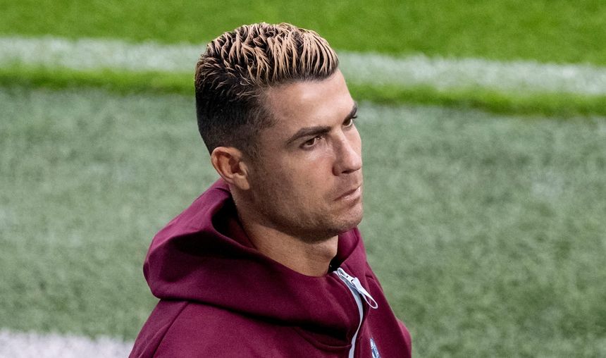 Na zdjęciu Cristiano Ronaldo w bordowej bluzie z kapturem, o krótkich włosach z jasnymi końcówkami.
