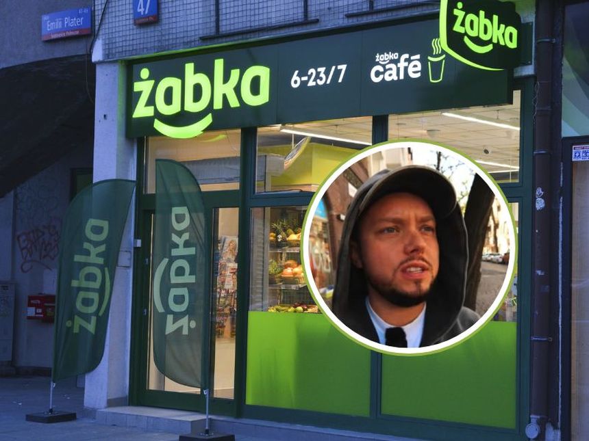 Zdjęcie przedstawia sklep Żabka z lodówką i osobą w bluzie, na tle zielonych banerów.