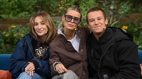 Mandaryna (Marta Wiśniewska) wraz z dziećmi siedzą na kanapie w ogrodzie, uśmiechając się do aparatu.