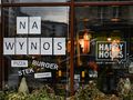 Witryna restauracji z napisami „NA WYNOS”, „PIZZA”, „BURGER”, „STEK”, „SHOARMA”.