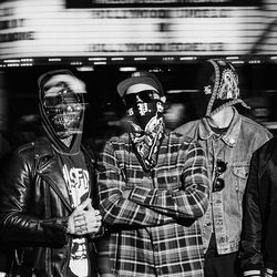 Grupa pięciu mężczyzn w maskach, ubranych w różne stylowe kurtki, na miejskiej ulicy.