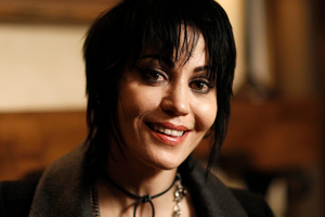 Joan Jett w 2010 roku. Na zdjęciu uśmiechnięta kobieta o ciemnych, krótkich włosach, w casualowym stroju.
