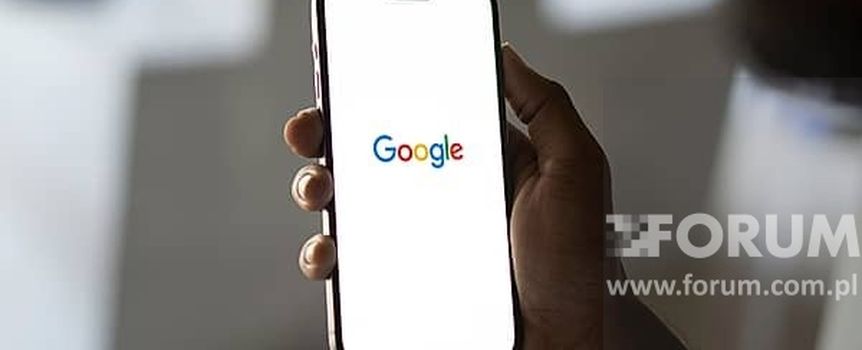 Na zdjęciu widać rękę trzymającą telefon z otwartą stroną Google. Tło rozmyte.