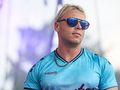 Skolim w niebieskim stroju sportowym i okularach przeciwsłonecznych, na tle sceny.