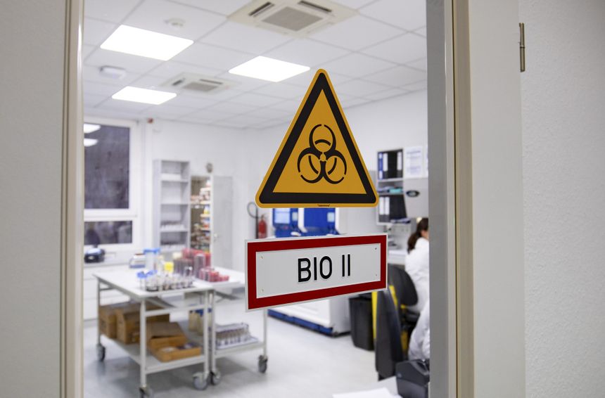 Drzwi do laboratorium z oznaczeniem „BIO II” i symbolem niebezpieczeństwa biologicznego.