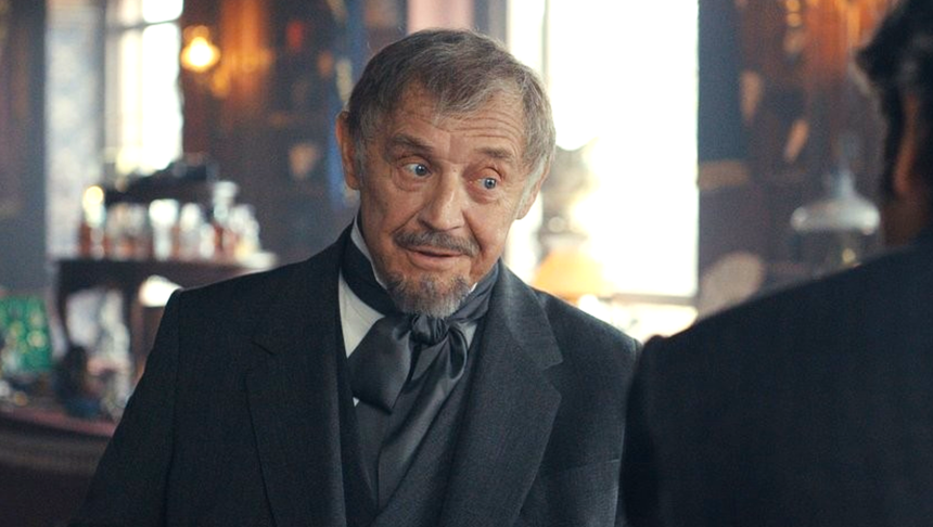 Mężczyzna w eleganckim stroju, z zamyśloną miną, w barze.