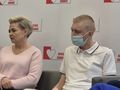 Dwoje ludzi na spotkaniu, kobieta w różowej bluzie i mężczyzna w białej koszulce.