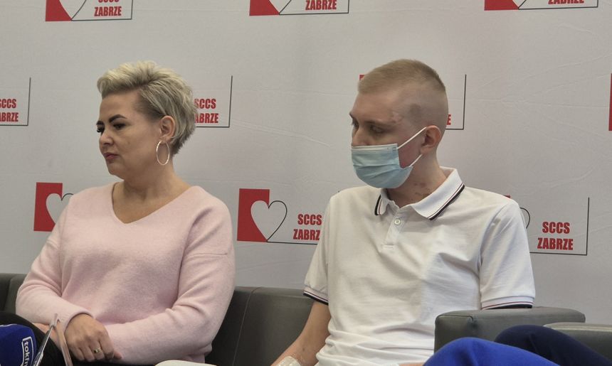 Dwoje ludzi na spotkaniu, kobieta w różowej bluzie i mężczyzna w białej koszulce.