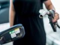Kobieta trzyma pistolet paliwowy, przygotowując się do tankowania samochodu.