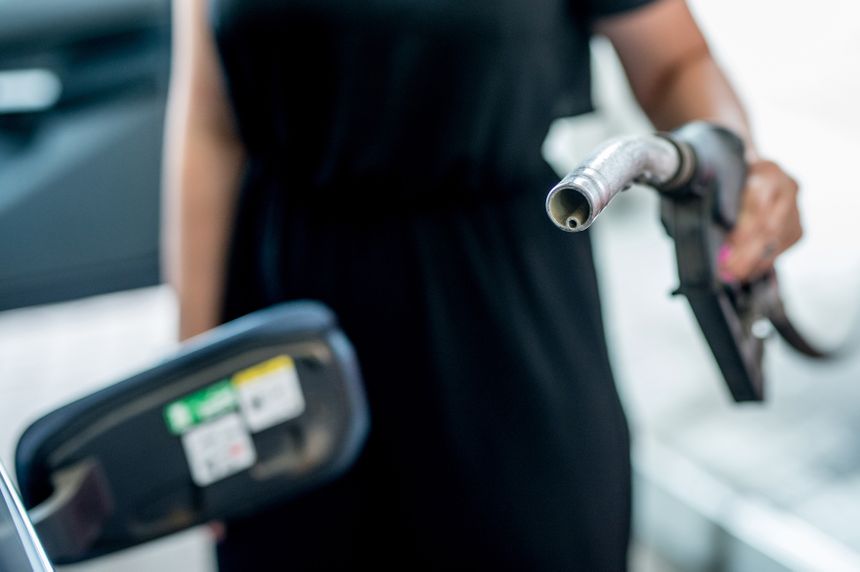Kobieta trzyma pistolet paliwowy, przygotowując się do tankowania samochodu.