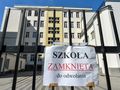 Na zdjęciu widoczna jest zamknięta szkoła, z tablicą informującą „SZKOŁA ZAMKNIĘTA do odwołania”.