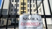 Na zdjęciu widoczna jest zamknięta szkoła, z tablicą informującą „SZKOŁA ZAMKNIĘTA do odwołania”.