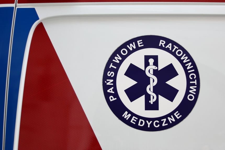Logo Państwowego Ratownictwa Medycznego na tle czerwono-białym i niebieskim.