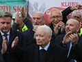 Grupa mężczyzn w garniturach, wiwatująca. Na pierwszym planie Jarosław Kaczyński.