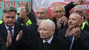 Grupa mężczyzn w garniturach, wiwatująca. Na pierwszym planie Jarosław Kaczyński.