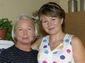 Bożena Dykiel z krótkimi włosami i Anna Guzik w kolorowej bluzce pozują razem w wnętrzu.