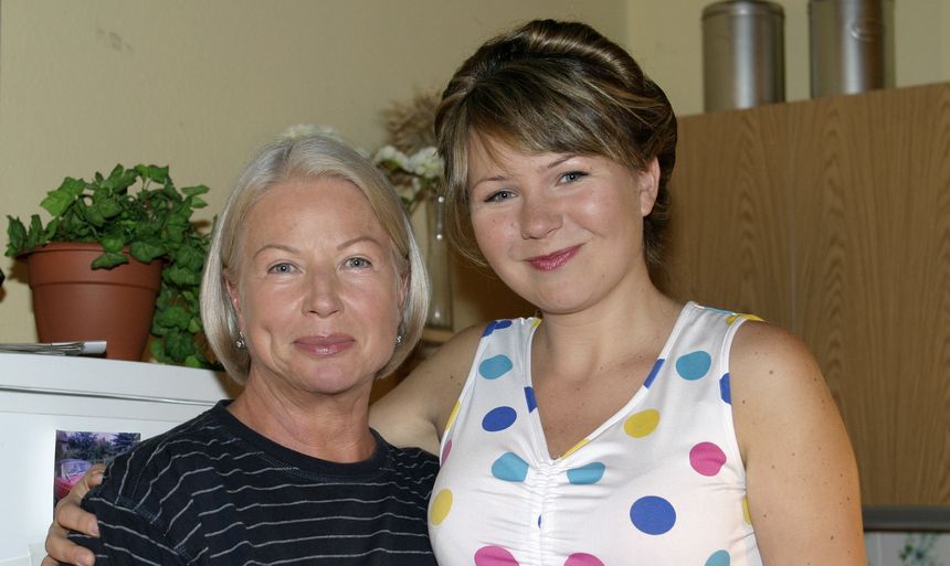 Bożena Dykiel z krótkimi włosami i Anna Guzik w kolorowej bluzce pozują razem w wnętrzu.