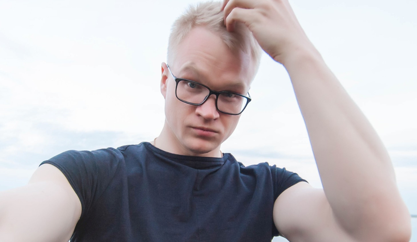 Blondyn w okularach poprawiający fryzurę