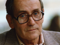 Tadeusz Konwicki w 1985. Mężczyzna w okularach, z lekko zmarszczonym czołem, patrzy z poważnym wyrazem twarzy.