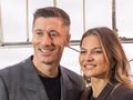 Robert i Anna Lewandowscy pozujący w miejskim krajobrazie z charakterystyczną siatką w tle.