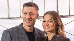 Robert i Anna Lewandowscy pozujący w miejskim krajobrazie z charakterystyczną siatką w tle.