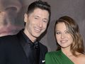 Robert Lewandowski w czarnym garniturze, Anna Lewandowska w zielonej sukience.