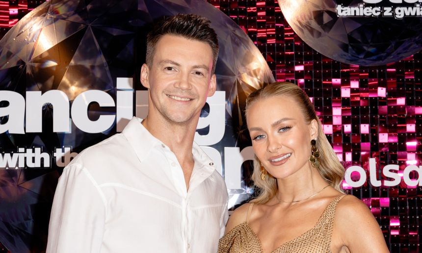 Para Krzysztof Kwiatkowski i Sara Janicka stoi na tle kolorowej sceny programu tanecznego.