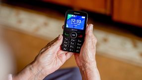 Zdjęcie przedstawia ręce osoby trzymającej telefon komórkowy z wyświetlaczem.