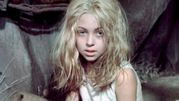 Na zdjęciu widać dziewczynkę z długimi, kręconymi, blond włosami i niebieskimi oczami.
