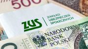 Na zdjęciu widoczny jest list z logo ZUS oraz banknoty polskie w tle.