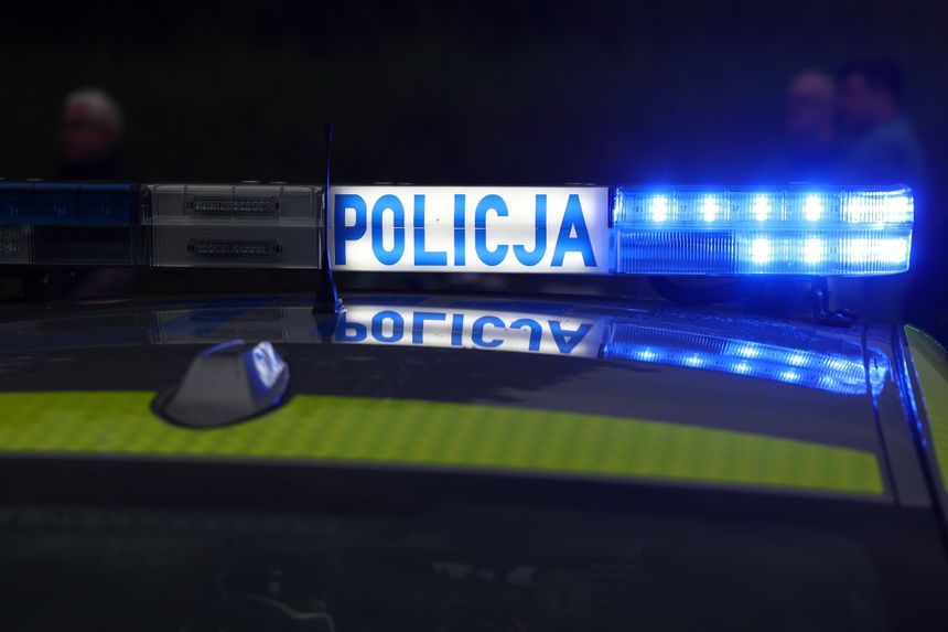 Niebieskie światło policyjne na dachu radiowozu z napisem 