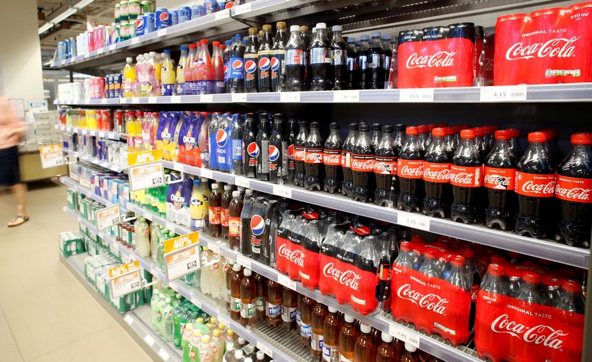 Półka z napojami gazowanymi i sokami, różne marki, w tym Coca-Cola i Pepsi.