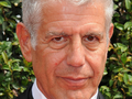 Anthony Bourdain. Mężczyzna z szarymi włosami, uśmiechnięty, w eleganckim ubraniu.